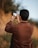 man in brown long sleeve shirt taking photo of sunset