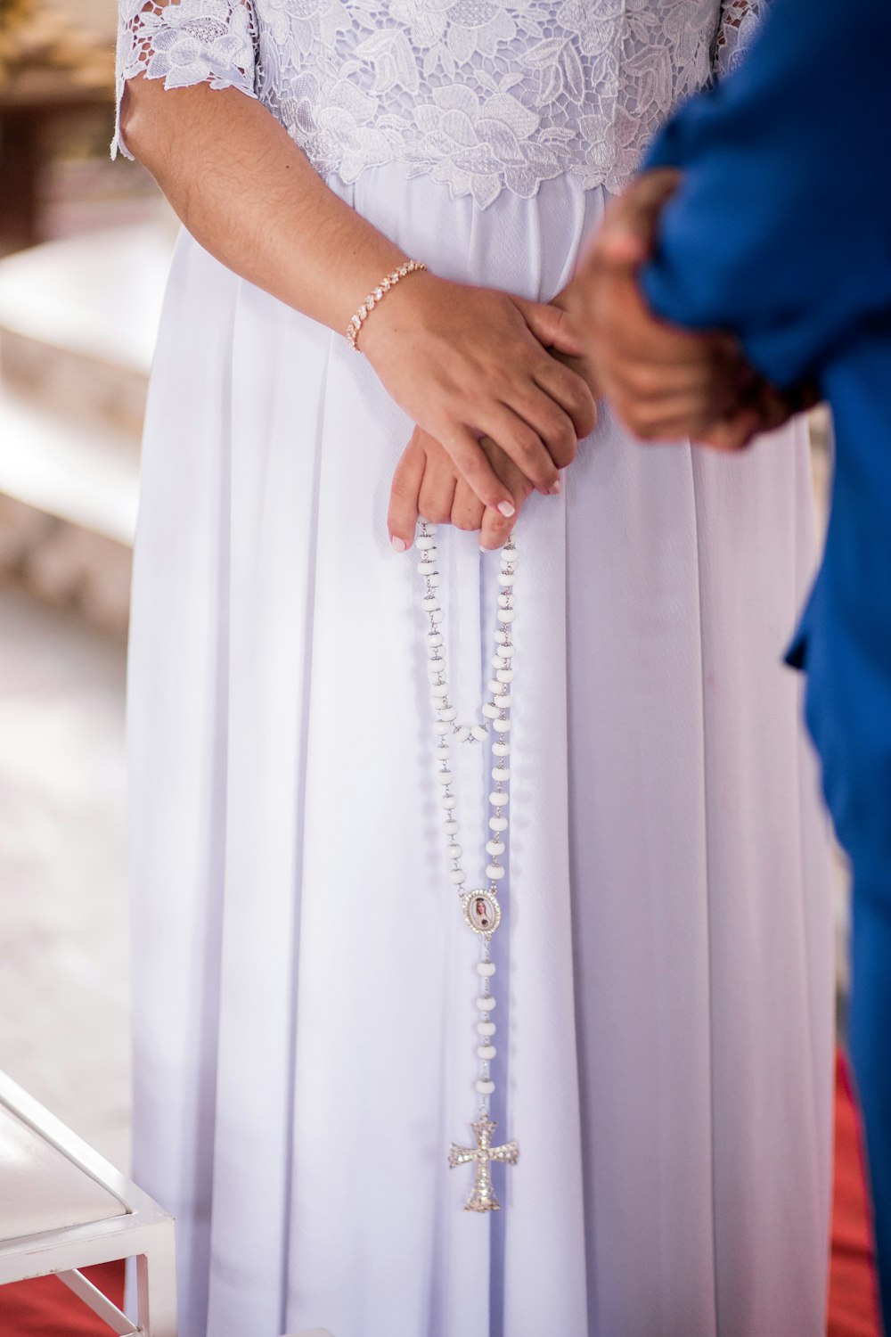 woman in white dress holding mans hand