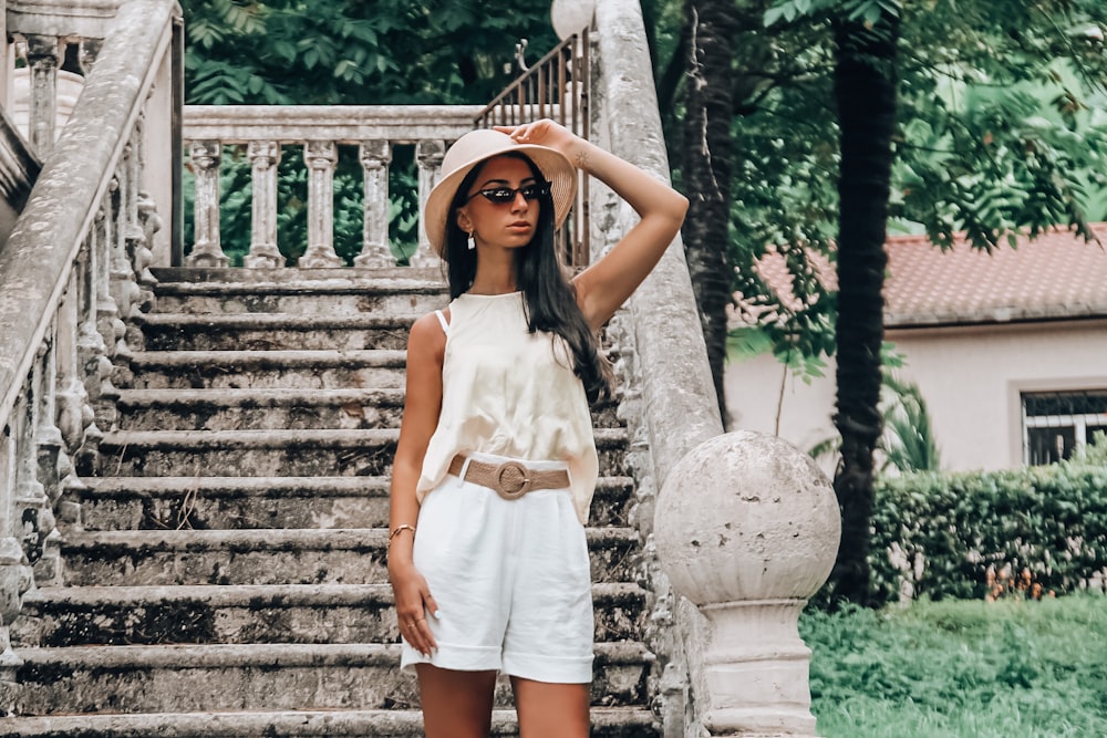 woman in white sleeveless dress standing on stairs