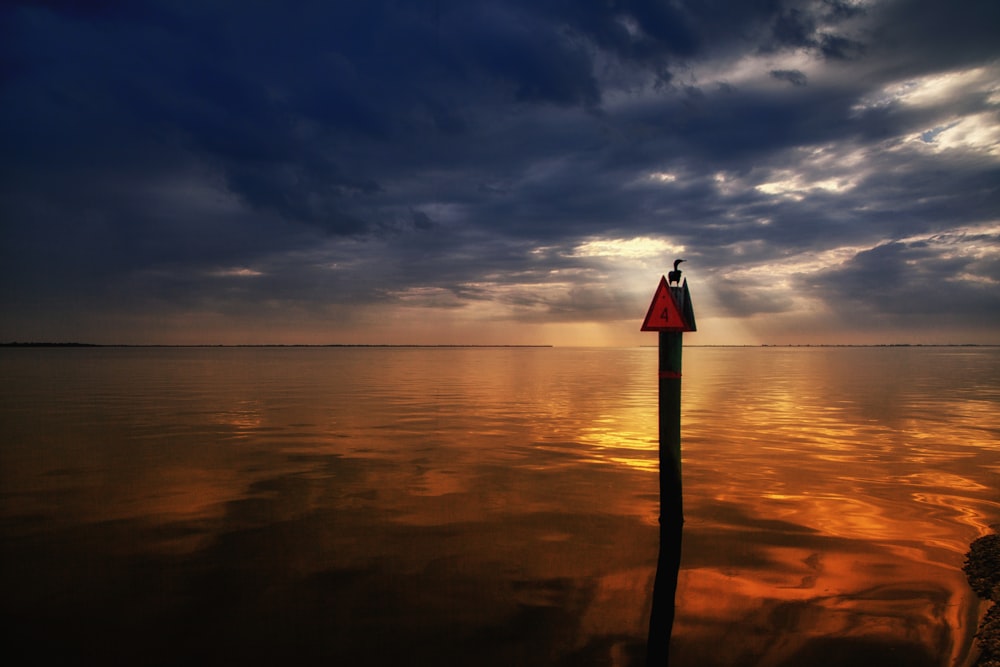 body of water under cloudy sky during sunset