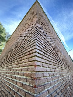Wide shot of a newly built brick wall under a clear blue sky.