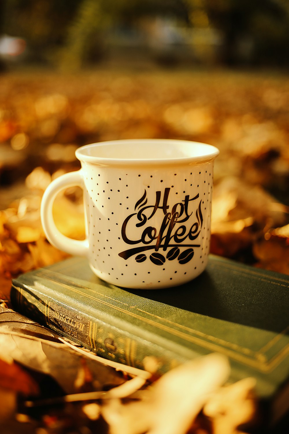 white and black ceramic mug on book