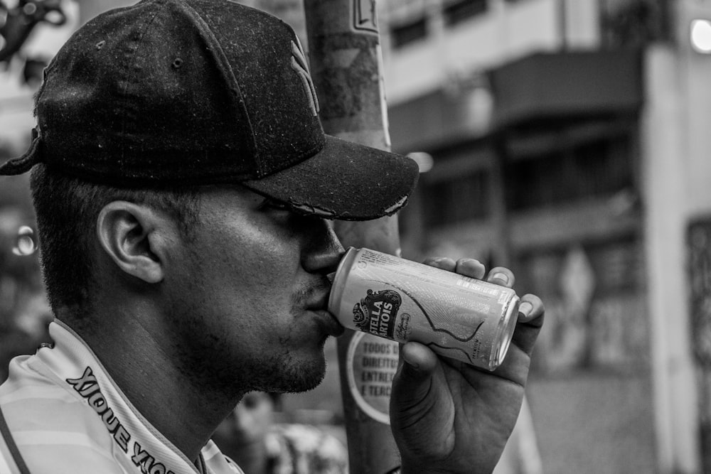 man drinking beer in grayscale photography