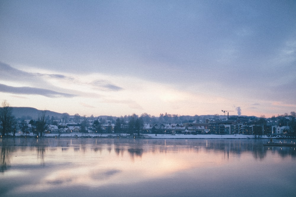 body of water near city buildings under blue sky during daytime