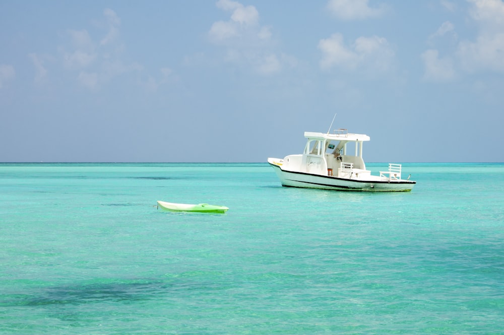 barco branco e verde no mar durante o dia
