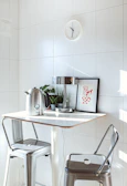 Bright kitchen nook with a small round table and colorful chairs.