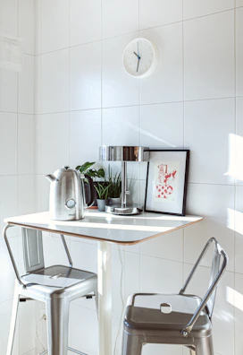 Bright kitchen nook with a small round table and colorful chairs.