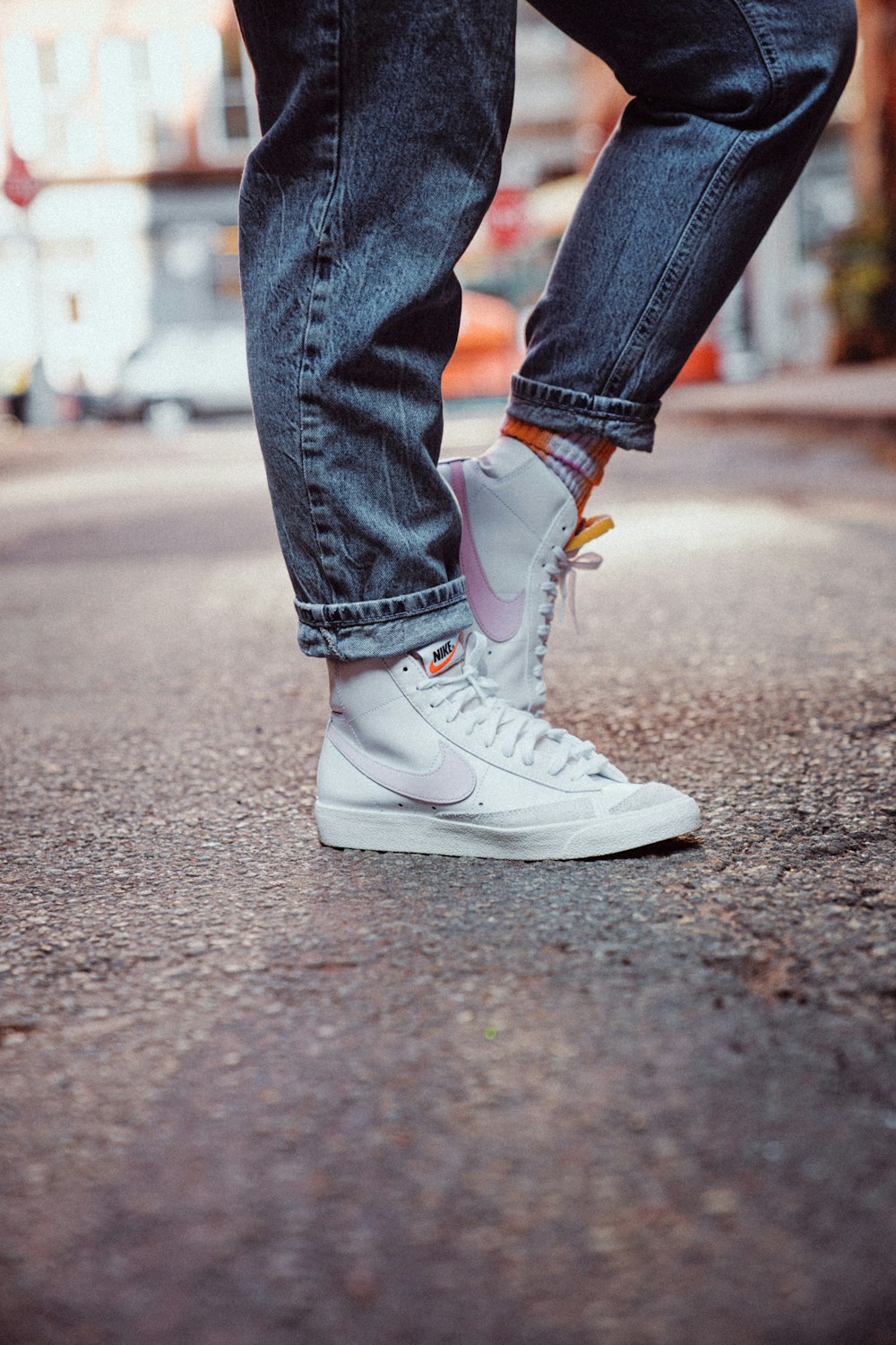 Persona in jeans blu denim e scarpe da ginnastica Nike bianche