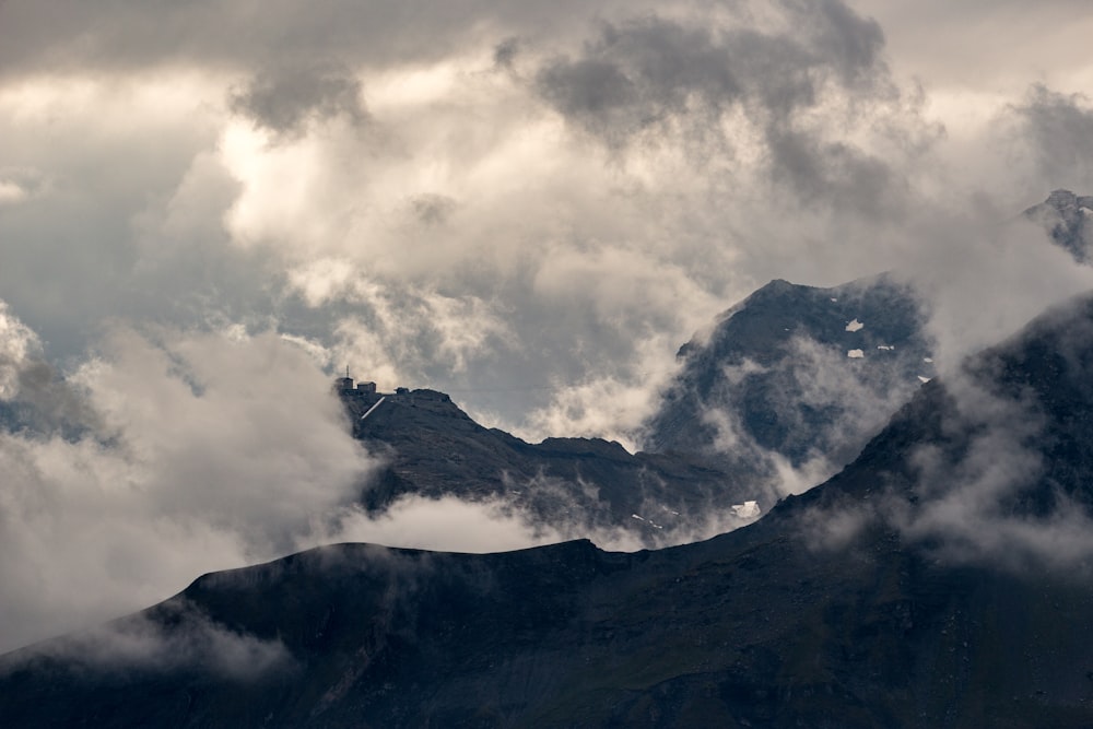 black and white mountain under white clouds