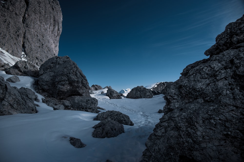 Montaña rocosa con nieve bajo el cielo azul durante el día