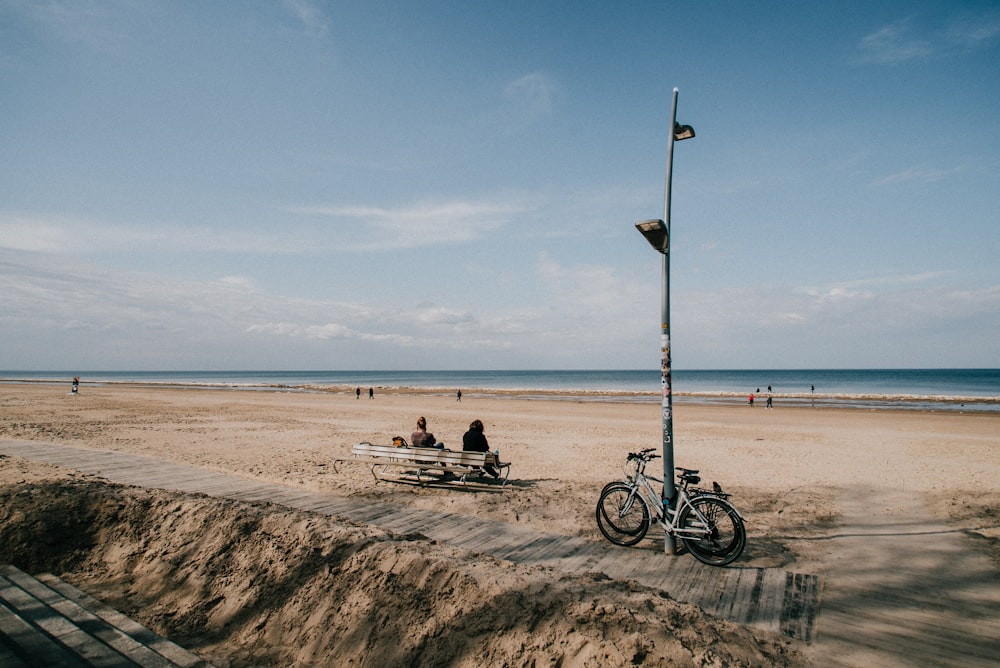 man and woman sitting on beach during daytime