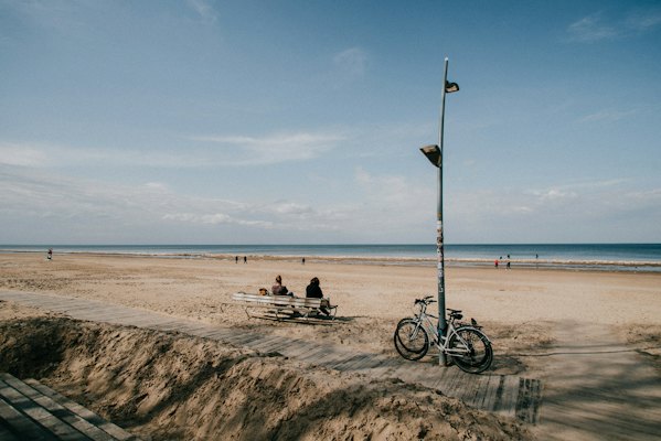 A bicycle against a lamppost on the wide sand at Jūrmala