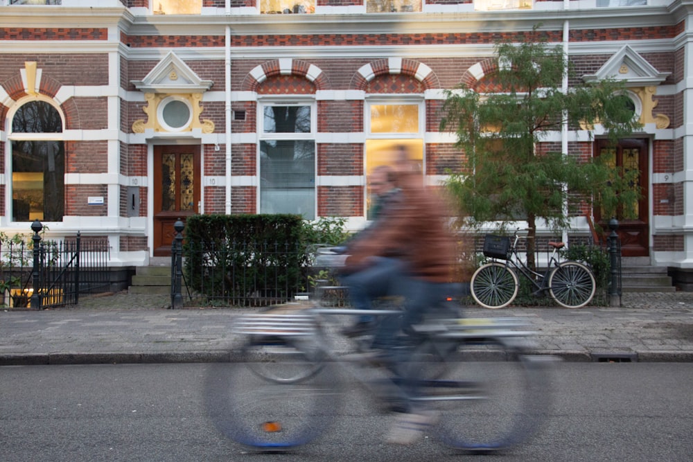 man in blue shirt riding bicycle on road during daytime