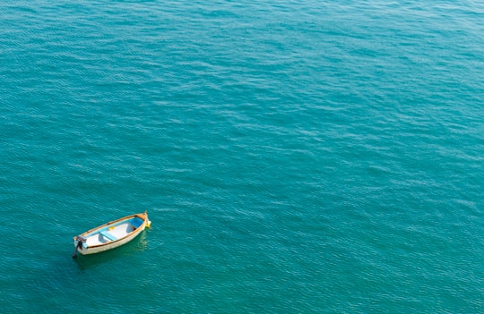 white and blue boat on green sea during daytime in Valletta Malta