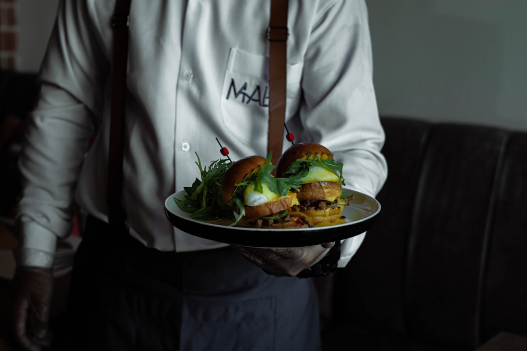 person in white button up shirt holding white ceramic bowl with food