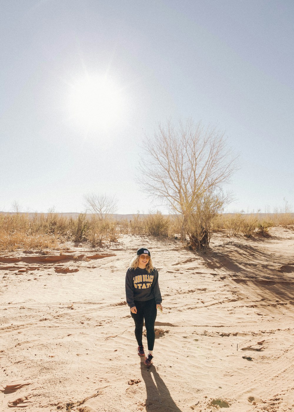 man in black jacket walking on brown field during daytime