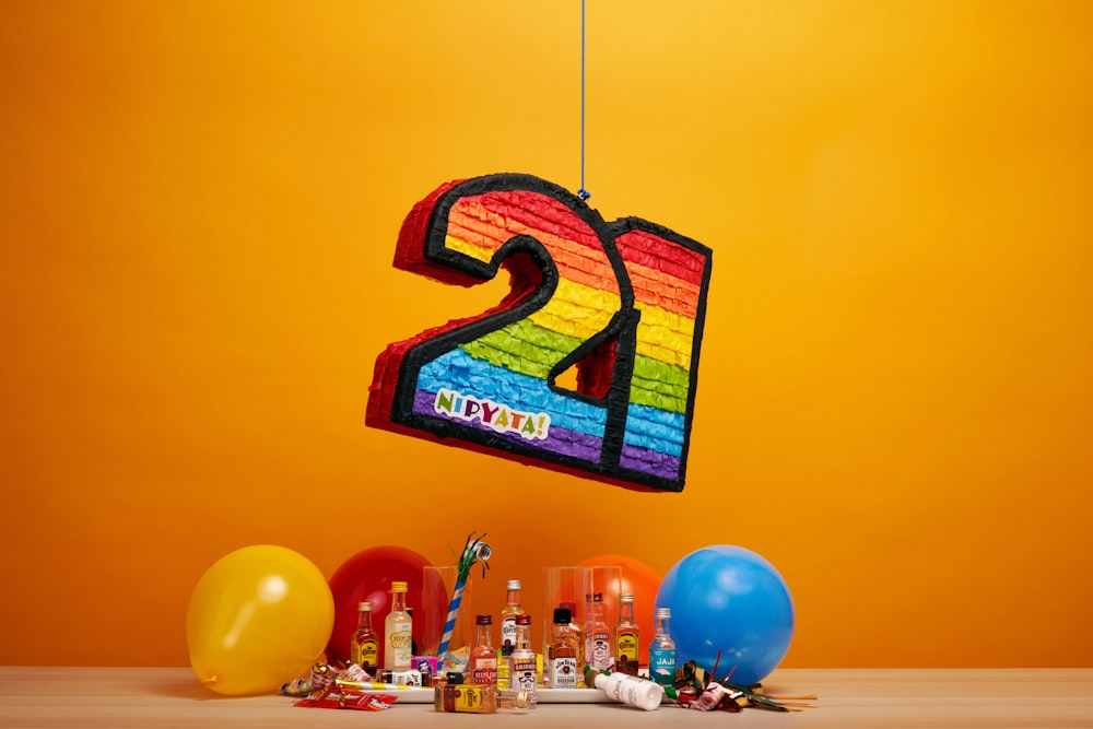 a number twenty sign hanging from a string next to balloons