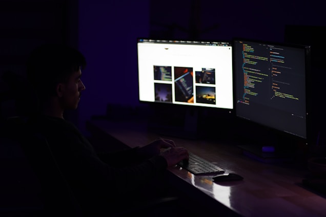 A developer happily coding at a desk with multiple screens showing code and codalyte’s dashboard.