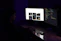 A glowing neon-lit workspace with a focused developer coding on multiple screens under a deep blue and purple pastel gradient.