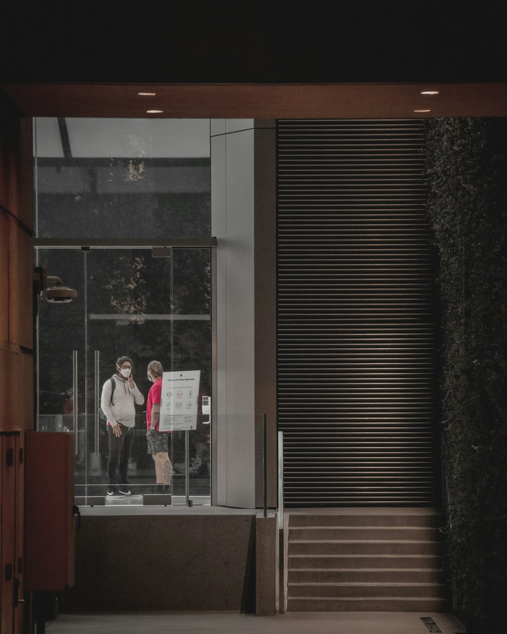 man in white dress shirt standing near glass window