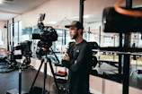 man in black long sleeve shirt standing near black camera