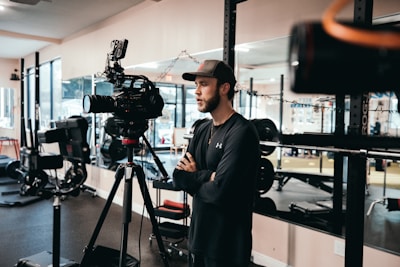 Close-up of a fitness influencer wearing branded apparel while recording content outdoors.