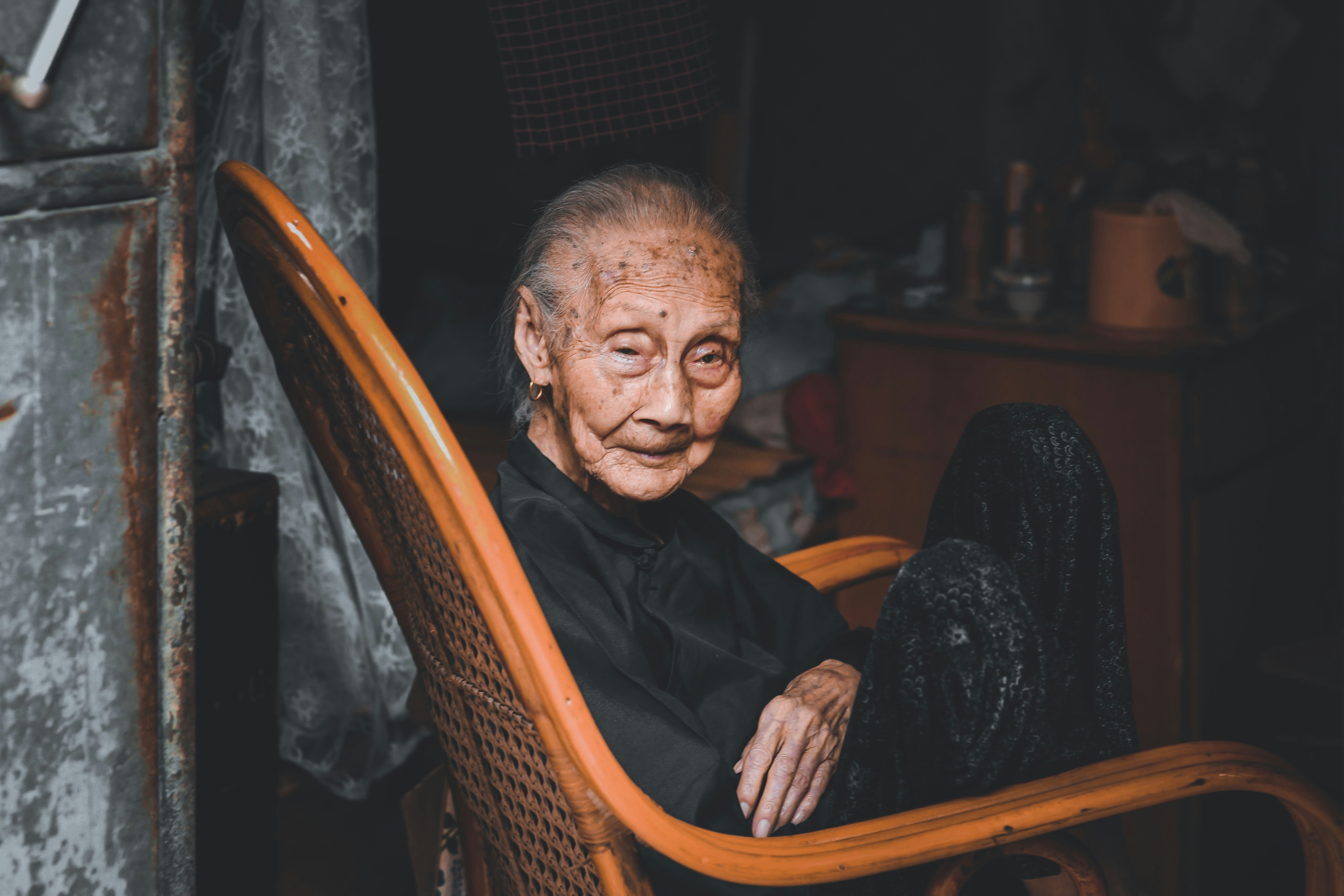 man in black shirt sitting on brown wooden armchair