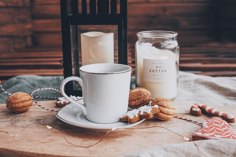 white ceramic mug beside cookies on white ceramic plate