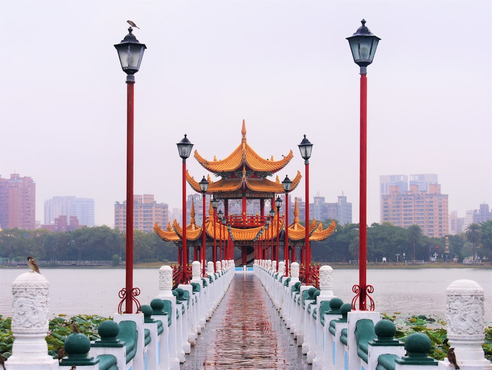 red and brown wooden bridge over body of water during daytime