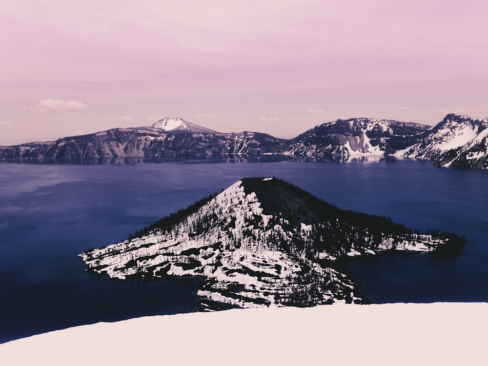 snow covered mountain near body of water during daytime