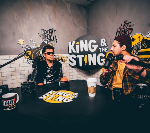 man in black and yellow jacket holding black microphone