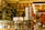 A cozy bookstore with shelves filled with a variety of books, adorned with festive garlands and small warmly-lit lights. Promotional signs for a 30% discount are visible. The atmosphere is enhanced by hanging decorations and organized displays, creating a warm and inviting environment.