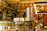 A cozy bookstore with shelves filled with a variety of books, adorned with festive garlands and small warmly-lit lights. Promotional signs for a 30% discount are visible. The atmosphere is enhanced by hanging decorations and organized displays, creating a warm and inviting environment.