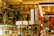 A cozy bookstore with shelves filled with a variety of books, adorned with festive garlands and small warmly-lit lights. Promotional signs for a 30% discount are visible. The atmosphere is enhanced by hanging decorations and organized displays, creating a warm and inviting environment.