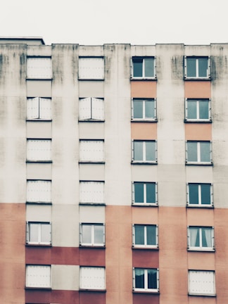 Close-up of a high-rise apartment building facade featuring off-white and navy colors
