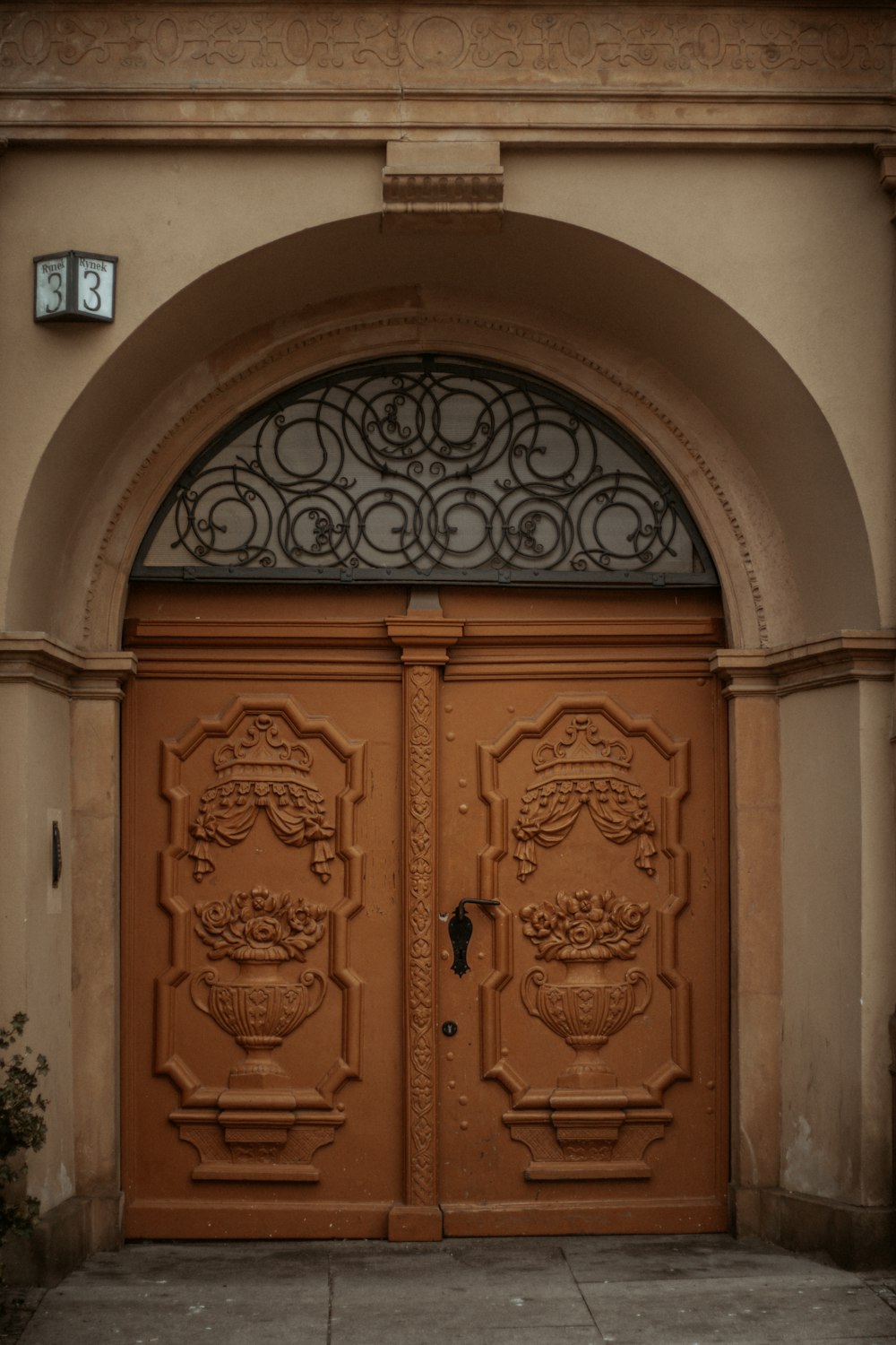 brown wooden door on white concrete wall