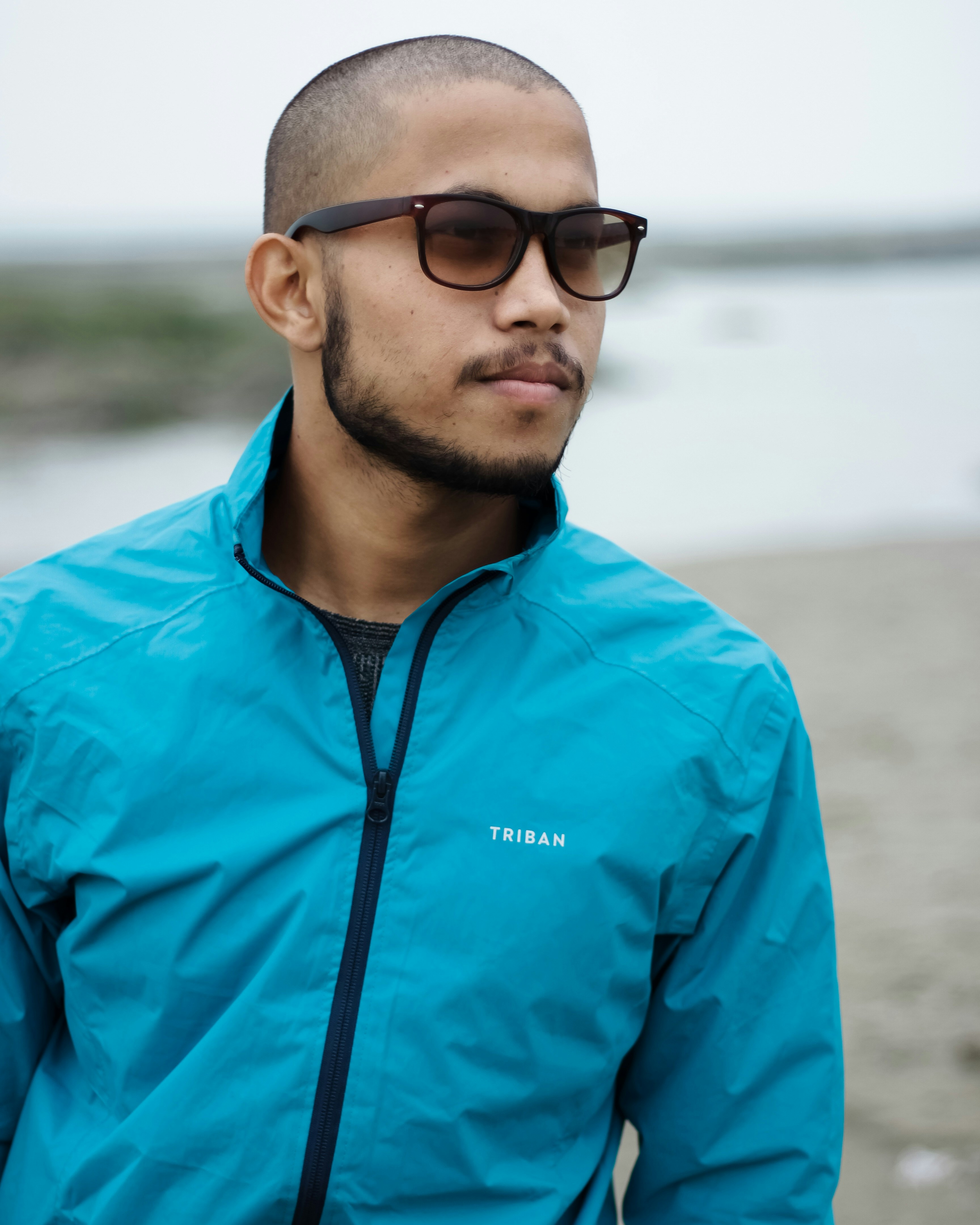 man in blue zip up jacket wearing black sunglasses