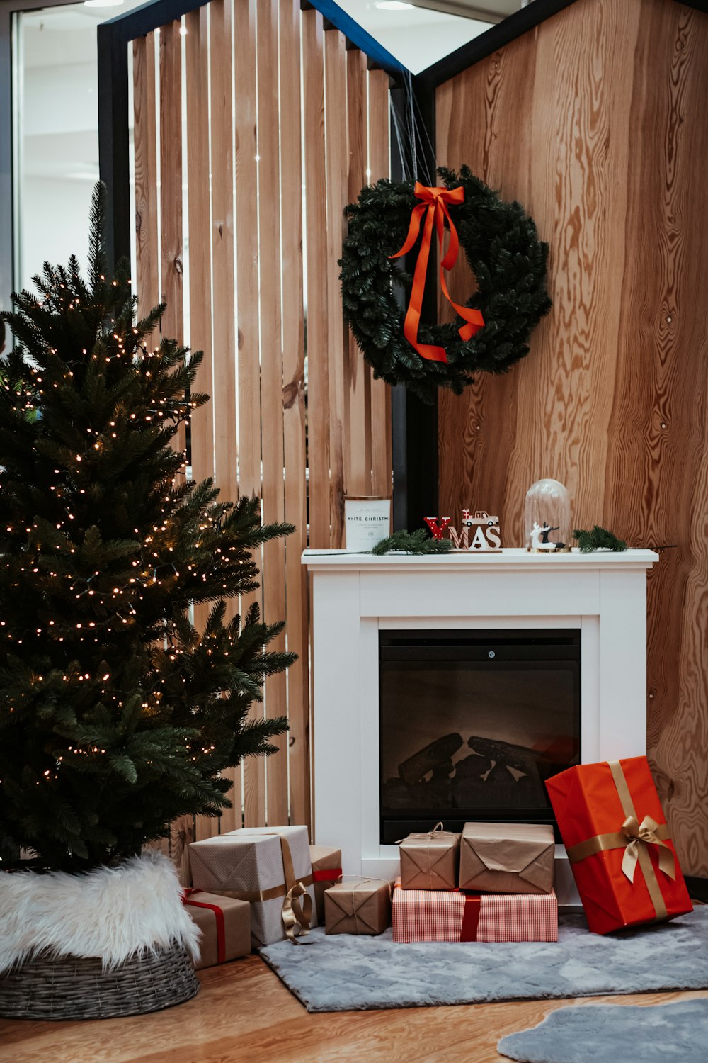 árvore de Natal verde com enfeites vermelhos e pretos na mesa de madeira branca