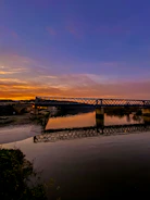 A completed government bridge spanning a river at sunset.