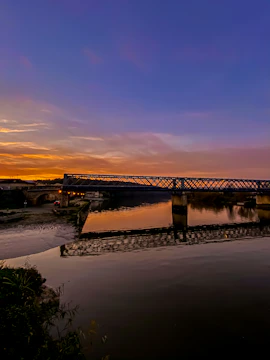 A completed government bridge spanning a river at sunset.