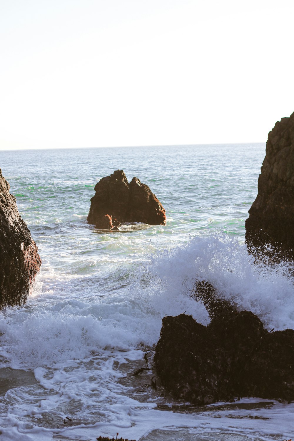 brown rock formation on sea water during daytime