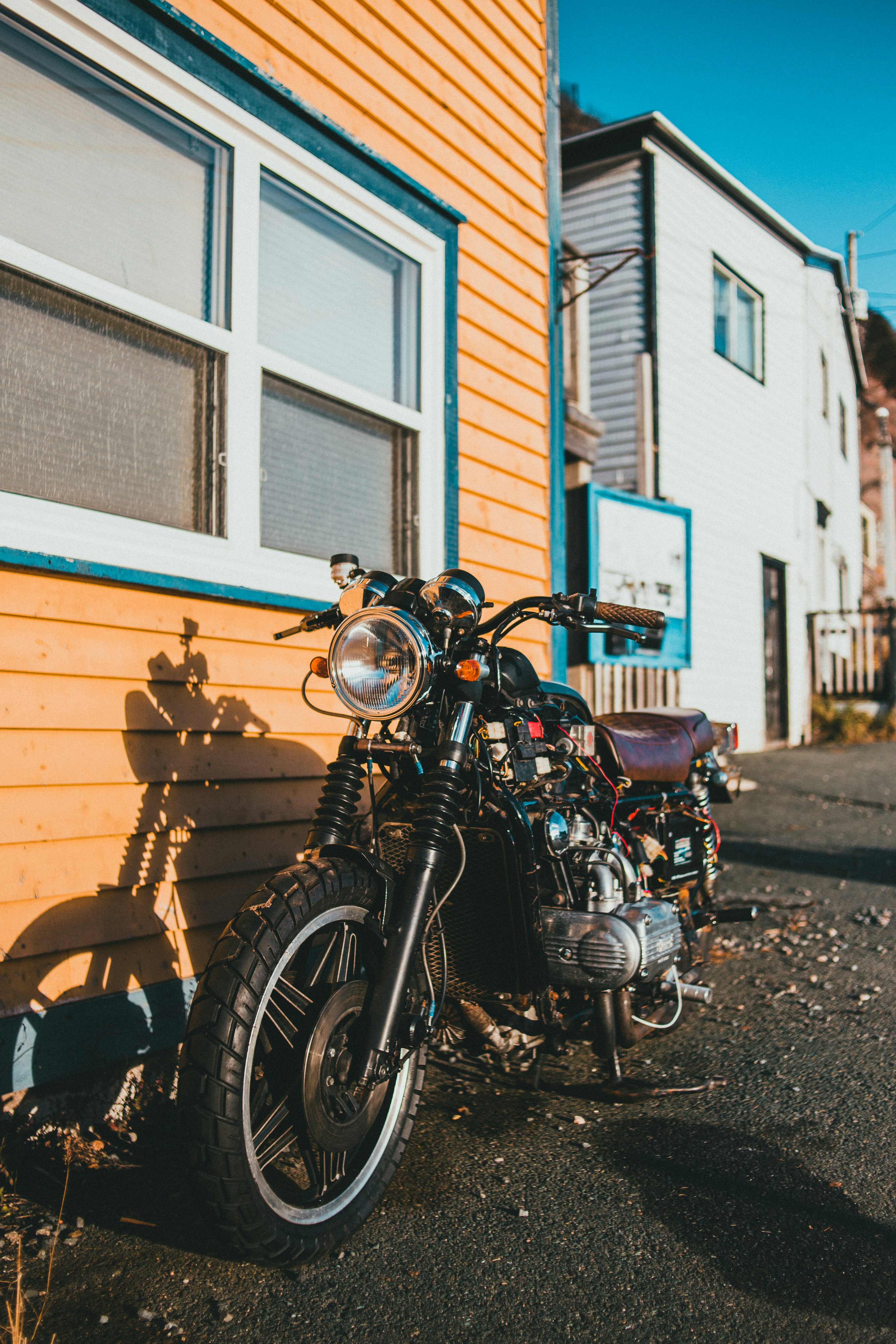 Motocicleta cruzadora preta e prateada estacionada ao lado do edifício de  concreto branco e marrom durante o dia foto – Imagem grátis sobre Veículo  na Unsplash, image size:3000x4500
