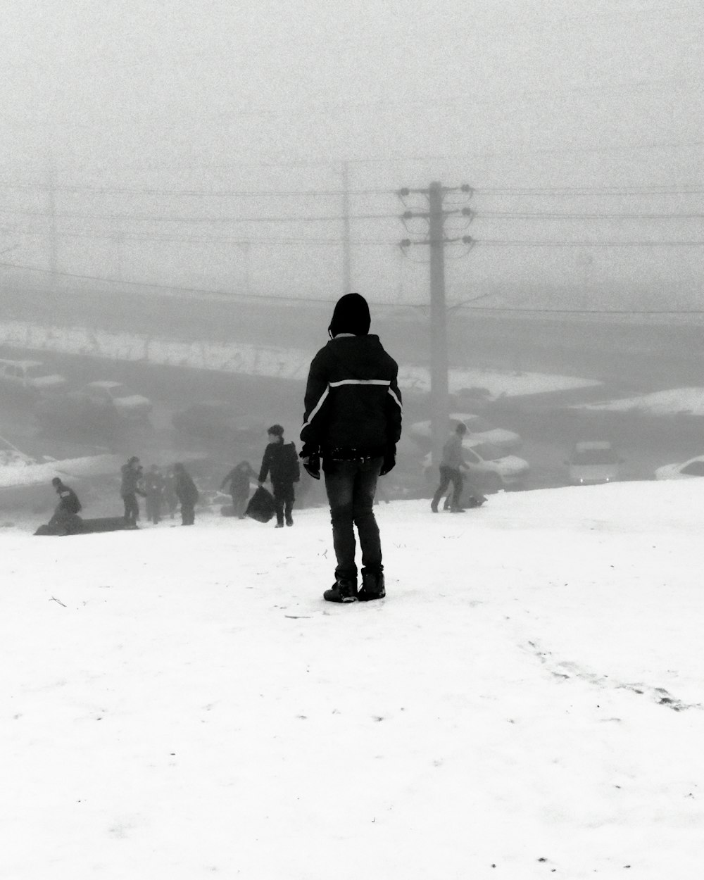 man in black jacket walking on snow covered field during daytime
