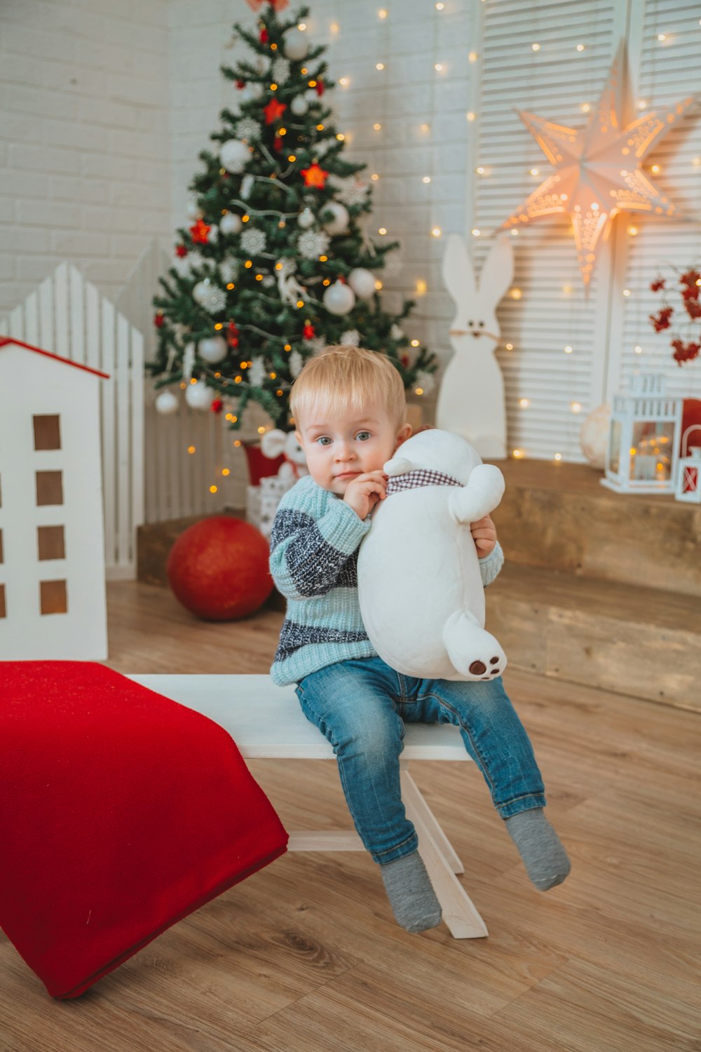 boy in blue denim jeans sitting on red sofa chair