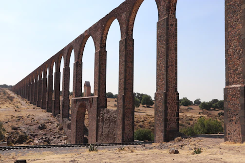 Wide shot of a completed aqueduct network with clear blue skies.