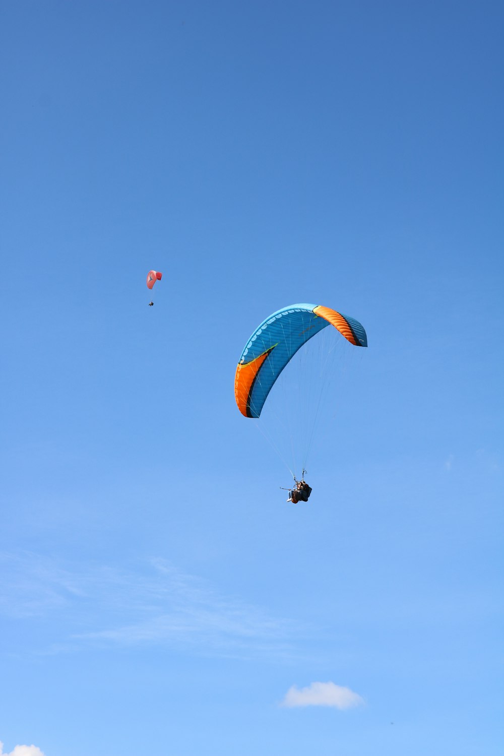 personne en parachute rouge et jaune dans les airs pendant la journée