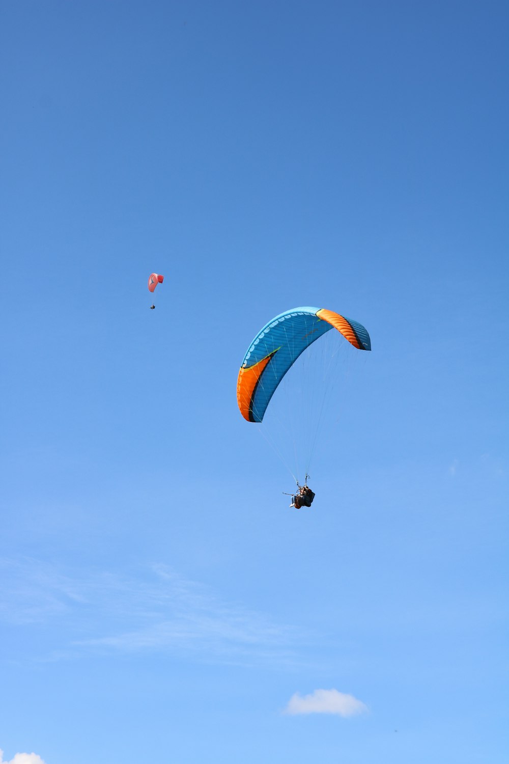 Person in rotem und gelbem Fallschirm in der Luft während des Tages