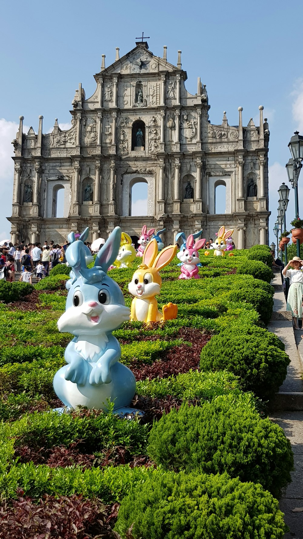 white and blue animal statue near green grass field during daytime