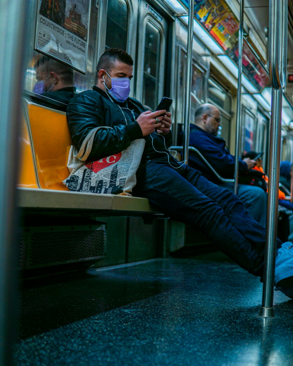 man in black and white jacket sitting on train seat