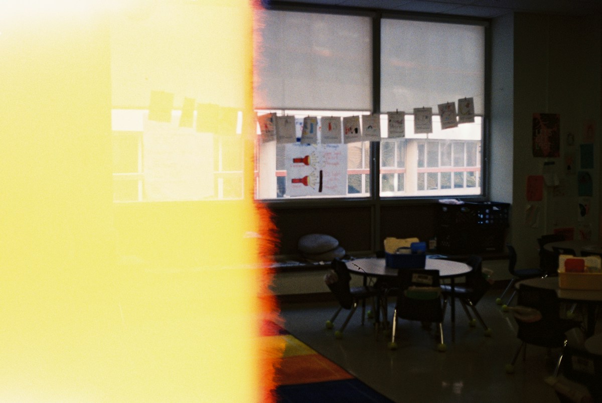 Elementary classroom with black chairs and a table near a window, setting for student recognition and award ideas.